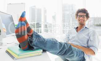 Relaxed casual man with legs on desk in office