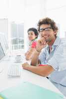 Smiling casual couple at desk in office