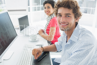 Casual couple using computers in office