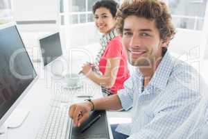Casual couple using computers in office