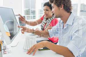 Casual couple using computer in office