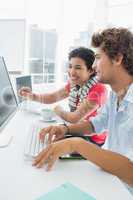 Casual couple using computer in office