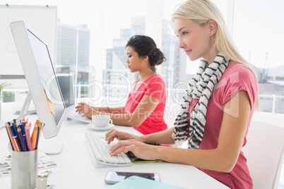 Casual young women using computers in office