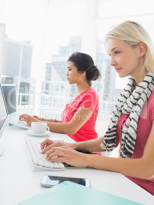 Casual young women using computers in office