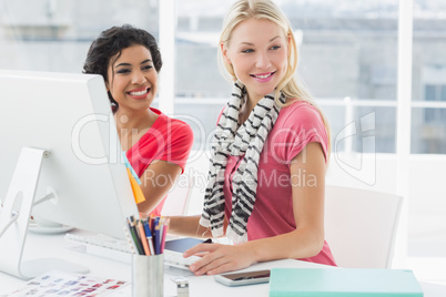 Colleagues using computer in bright office