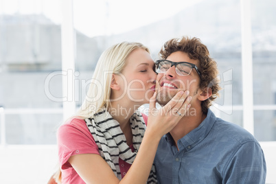 Woman kissing man on his cheek