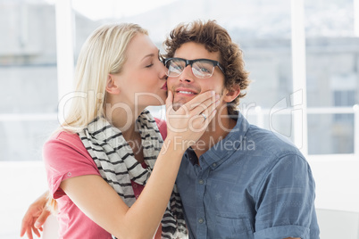 Woman kissing man on his cheek