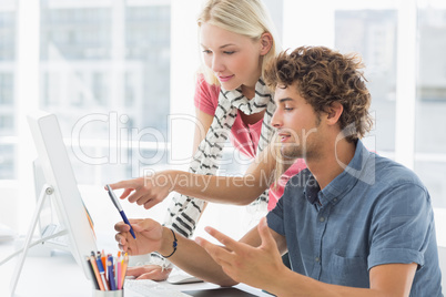 Casual couple using computer in bright office
