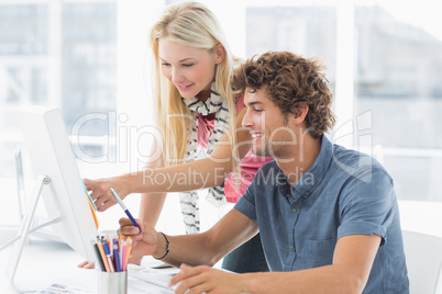 Casual couple using computer in bright office