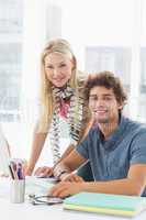 Casual business couple using computer in bright office