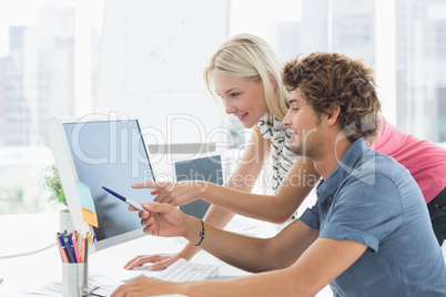 Casual couple using computer in office