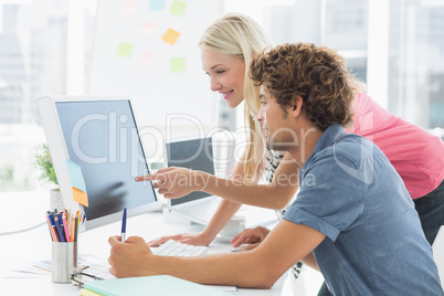 Casual couple using computer in office