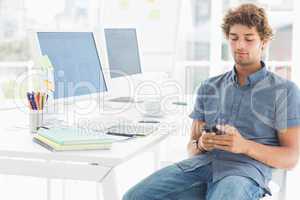 Man text messaging in a bright office