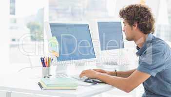 Casual young man using computer in office