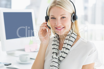 Smiling casual young woman with headset in office