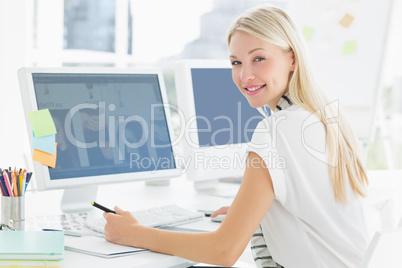 Casual young woman using computer in office