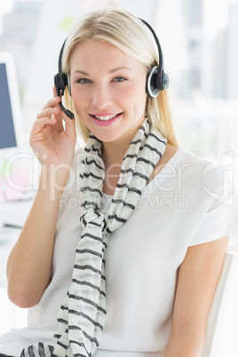 Smiling casual young woman with headset in office