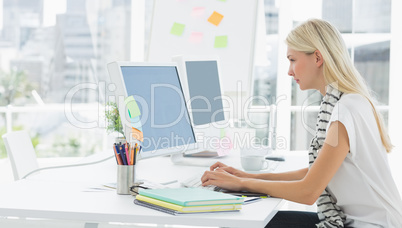 Casual young woman using computer in office