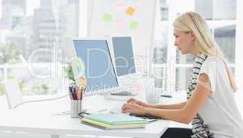 Casual young woman using computer in office