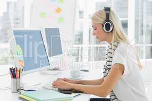 Casual woman with headset using computer in office