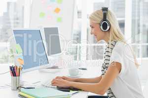 Casual young woman with headset using computer in office