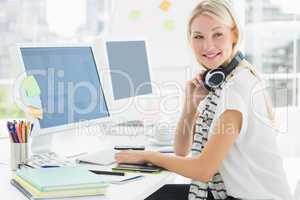 Casual woman with headset at computer desk in office