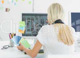 Rear view of a casual woman using computer in office