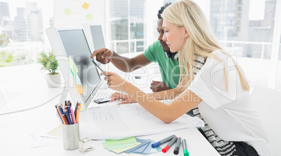 Casual couple using computer in office