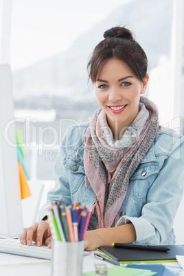 Smiling casual woman using computer in office