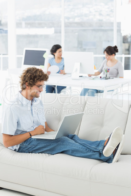 Man using laptop with colleagues at creative office