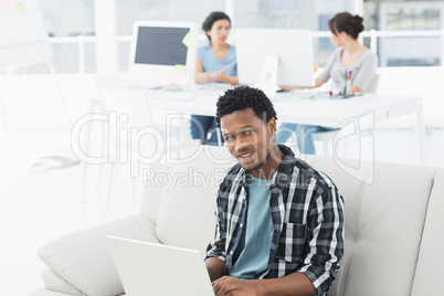 Man using laptop with colleagues at creative office