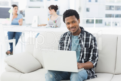 Man using laptop with colleagues at creative office