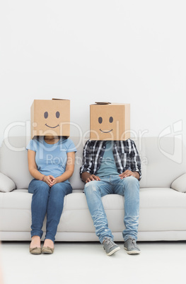 Young couple with happy smiley boxes over faces