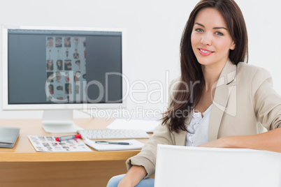 Female artist sitting at desk with computer in office