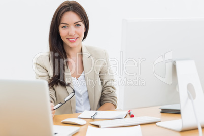 Young woman with computers at desk in office