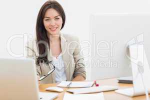 Young woman with computers at desk in office