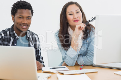 Casual business couple using computers in office