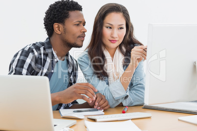 Casual couple using computer in office