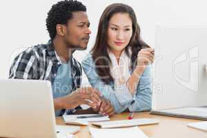 Casual couple using computer in office