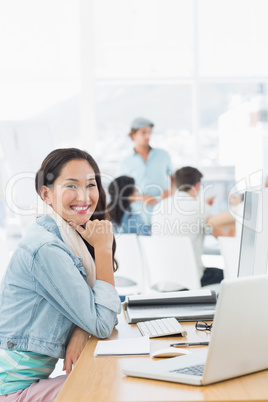 Casual woman with colleagues behind in office