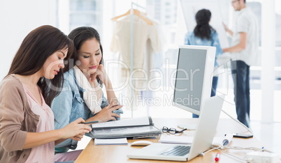 Female artists working at desk in creative office