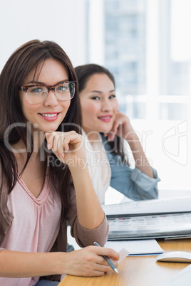 Portrait of two casual female artists working at desk