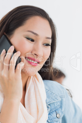 Beautiful casual young woman using mobile phone in office