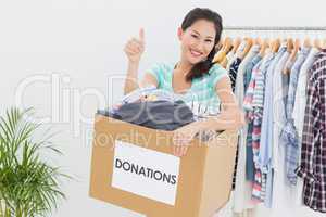 Woman with clothes donation gesturing thumbs up