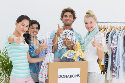 People with clothes donation gesturing thumbs up
