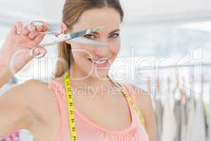 Close-up of a beautiful female fashion designer holding scissors