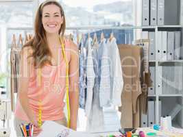 Smiling female fashion designer working in studio