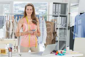 Female fashion designer with laptop and cellphone