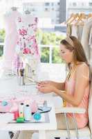 Young female fashion designer working on fabrics