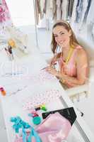 Young female fashion designer working on fabrics